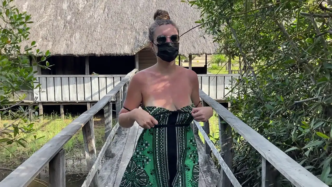 Blonde MILF exhibitionist shows off her big tits by a lake