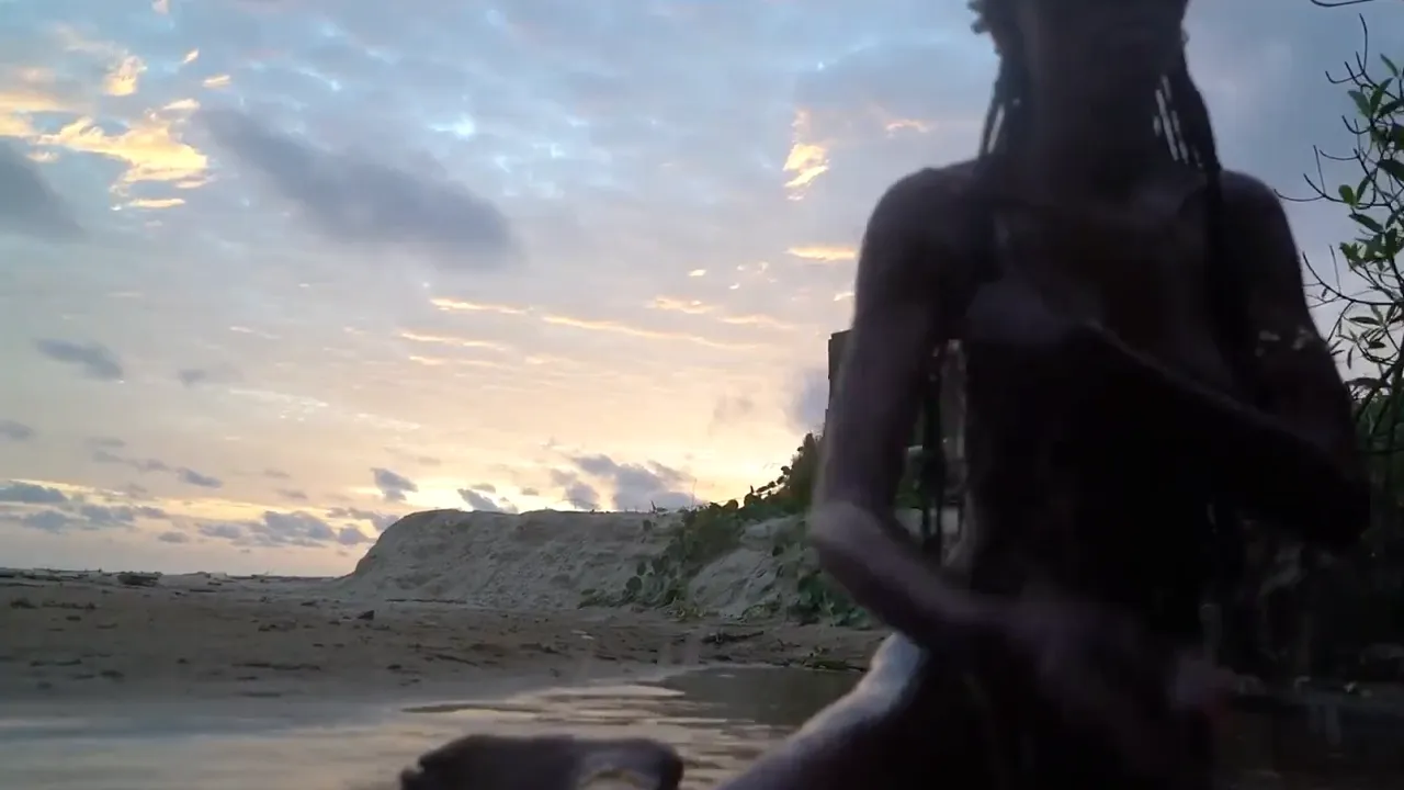 Skinny African naked babe strolls alone on the beach