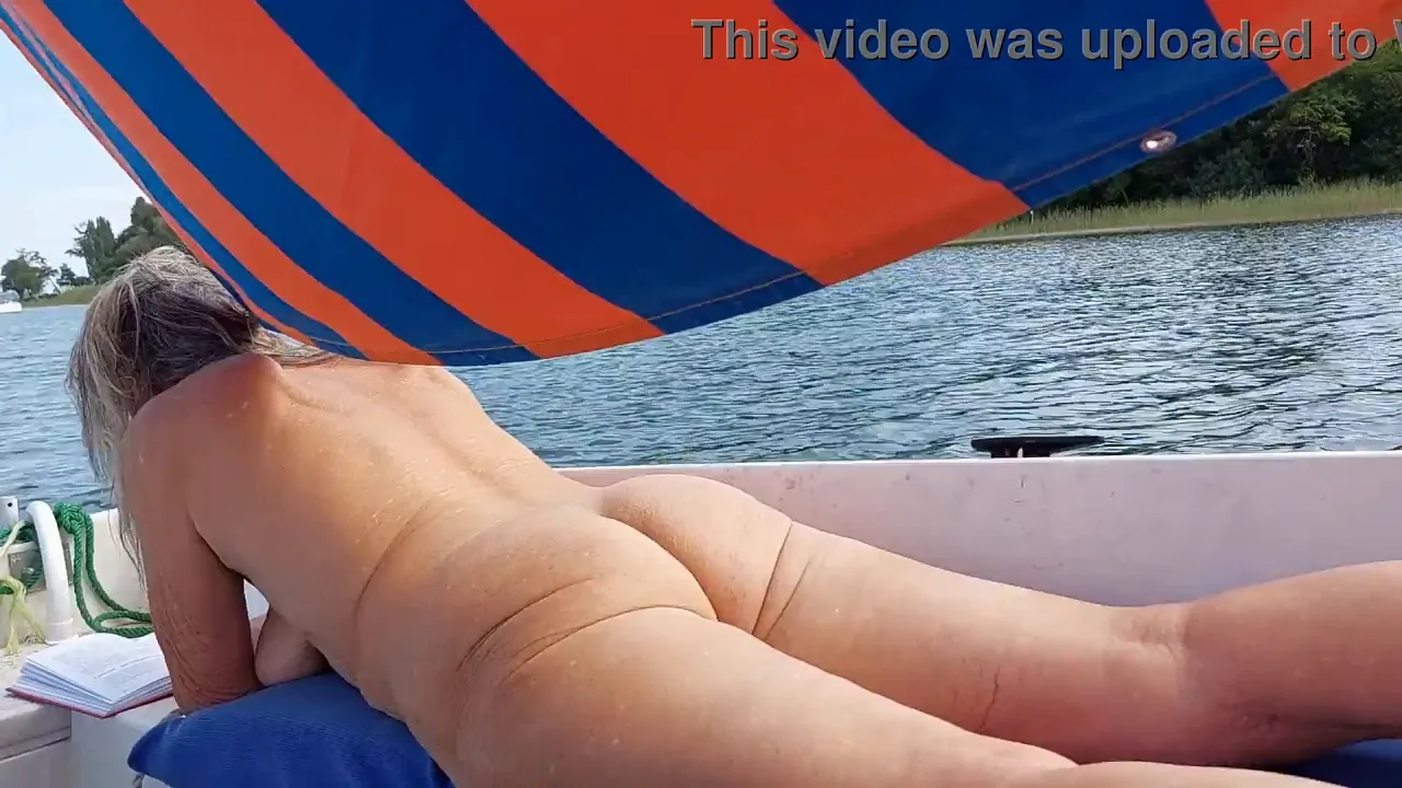Blonde mature woman shows off her big naked booty on a sailboat