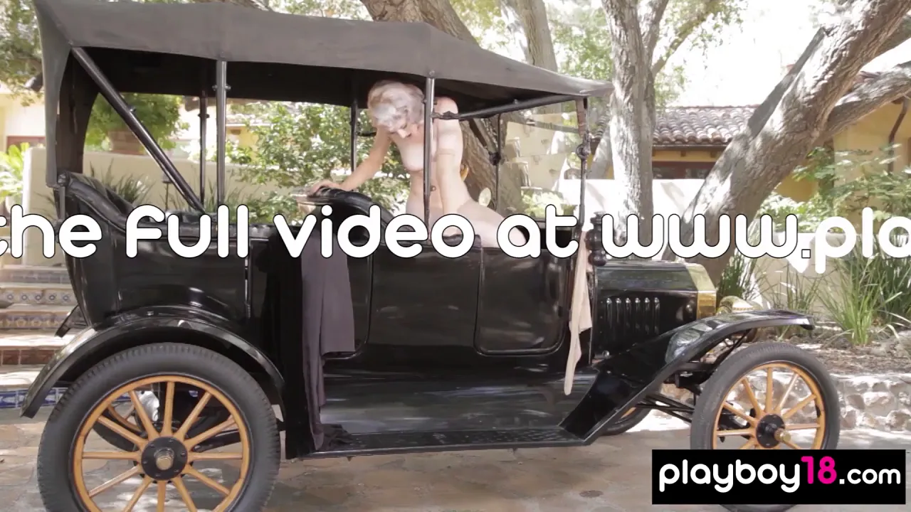 Glamour model Maria Fedorova poses naked in a classic car outdoors