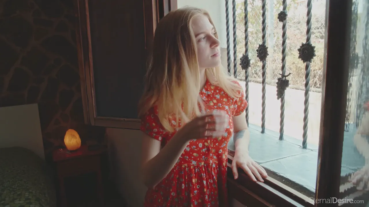 Shayla, a blonde solo model wearing socks, poses nude for her creator's camera