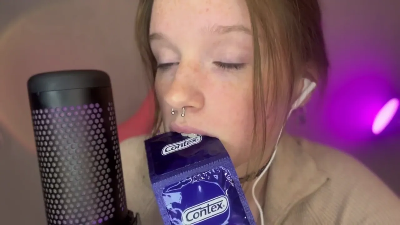 Beautiful girl with freckles plays with a condom in her mouth for ASMR