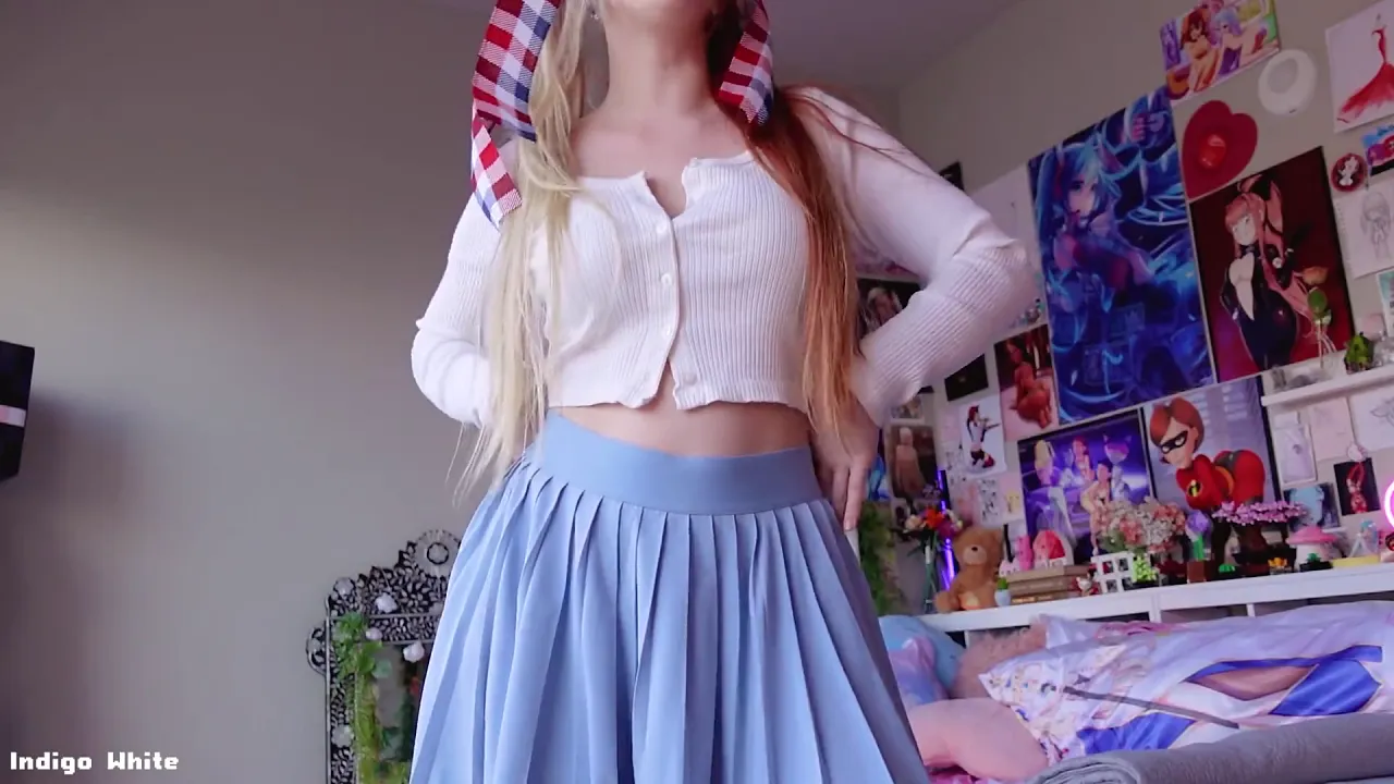 Indigo White strips for the camera in pigtails while a man films her