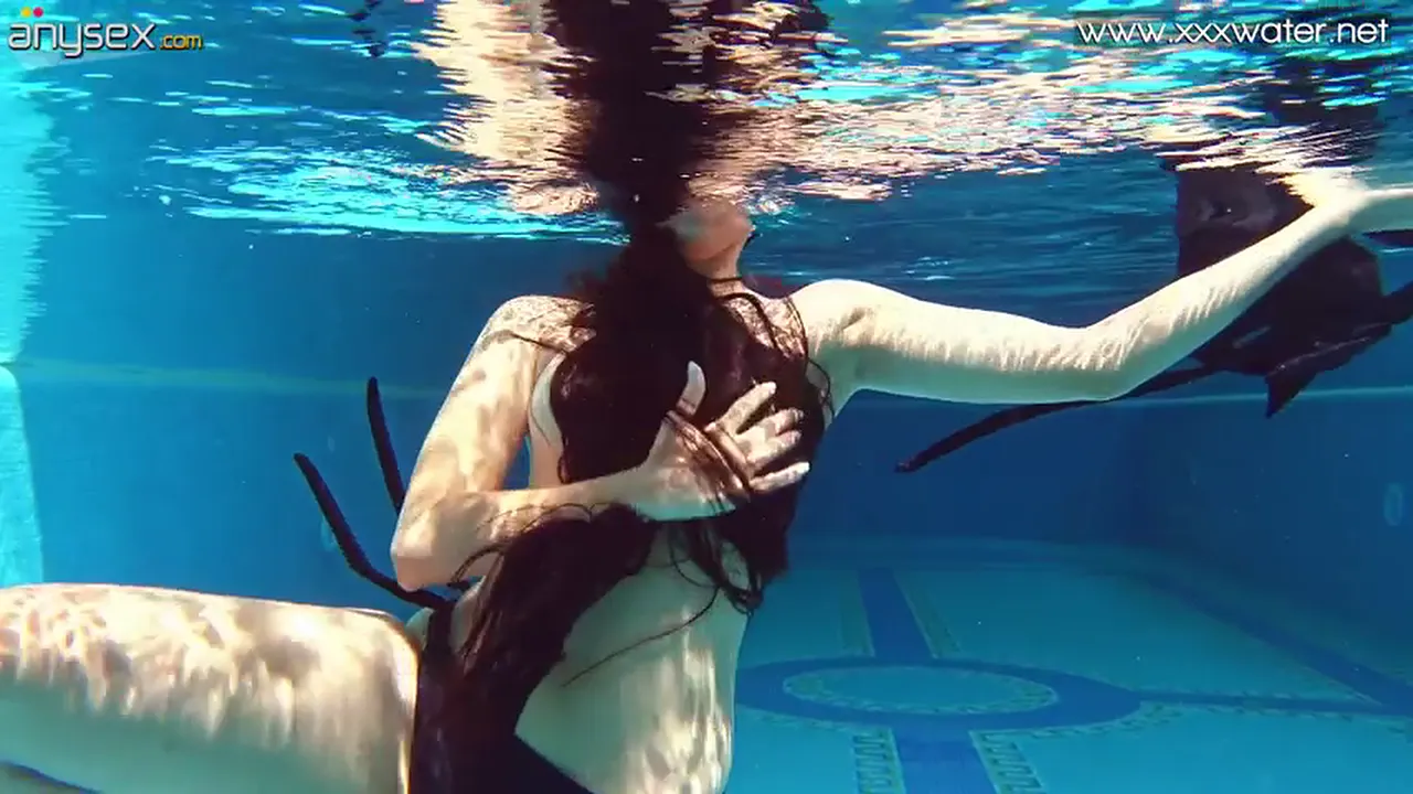 Andriena De Luxe strips and shows off her big booty and perky tits under the water